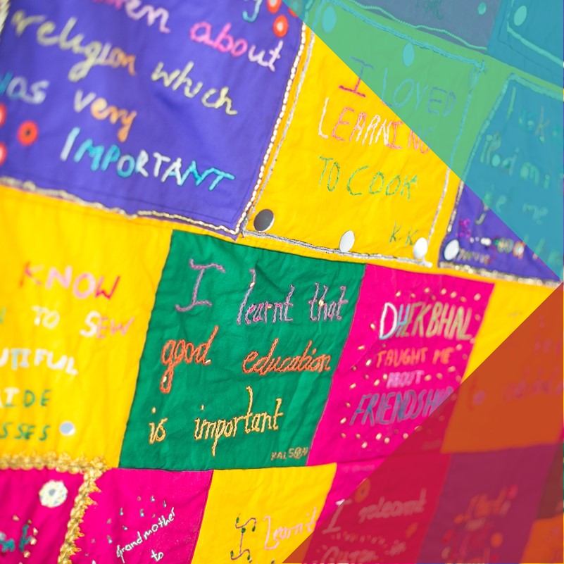 A photo of a colourful patchwork quilt with statements embroidered into it about what a person learned